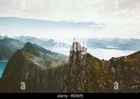 Norwegen Bergsteigen reisen Mann stand auf einer Klippe Berg über dem Fjord Abenteuer Klettern extreme lifestyle Reise Urlaub Luftbild landsca Stockfoto