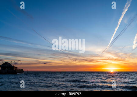 Sonnenaufgang über dem Strand und Hafen in Broadstairs in Kent. Dünne Band von Clear orange sky am Horizont mit blauem Himmel und Fetzen von dünnen weißen Wolken. Stockfoto