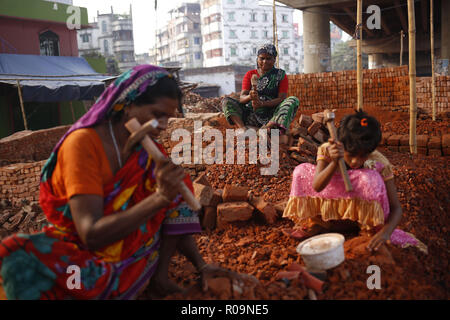 Dhaka, Bangladesch. 3. November, 2018. Weiblichen Tagelöhner mit einem Kind bricht Ziegelsteine in einer Ziegelfabrik in Keraniganj. Weibliche Tag labores verdienen rund 20 US-Dollar pro Woche jeden Tag über acht Stunden, wie sie vom Land in die Hoffnung auf ein besseres Leben. Credit: MD Mehedi Hasan/ZUMA Draht/Alamy leben Nachrichten Stockfoto