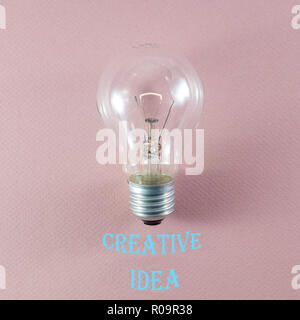 Kreative Idee und Innovation Konzept über leuchtet die Glühbirne auf rosa Hintergrund und entsprechenden Text in moderne Schrift Stockfoto