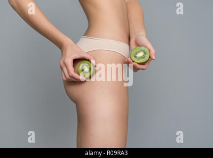 Verschiedene Ausdruck von jungen Mädchen mit Kiwi frisches Obst auf neutralem Hintergrund Stockfoto