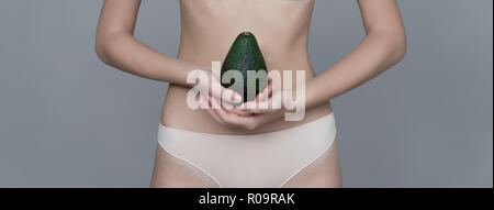 Verschiedene Ausdruck von jungen Mädchen mit Avocado frisches Obst auf neutralem Hintergrund Stockfoto