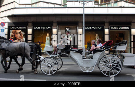 Eine riesige, Kutsche, mit seinen Passagieren, vorbei an der Louis Vuitton Kaufhaus in Berlin. Stockfoto