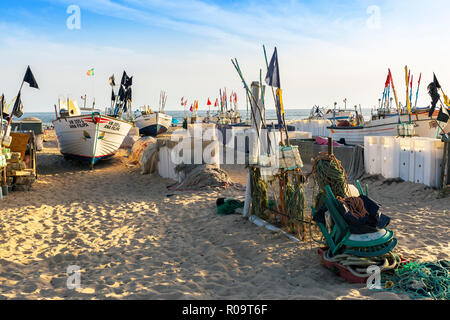 Lokalen Fischerboot von Fischen umgeben schwimmt auf der Strand von Monte Gordo, Algarve, Portugal in der Abendsonne Stockfoto