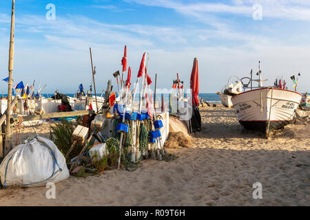 Lokalen Fischerboot von Fischen umgeben schwimmt auf der Strand von Monte Gordo, Algarve, Portugal in der Abendsonne Stockfoto