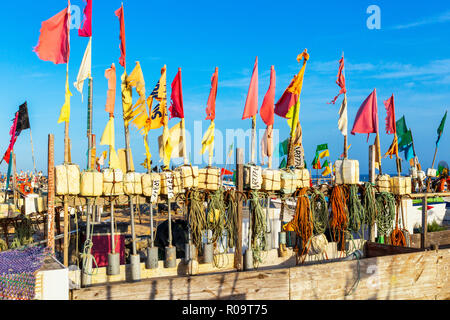 Angeln schwebt und Flaggen, die in der Abendsonne am Strand von Monte Gordo, Algarve, Portugal Stockfoto