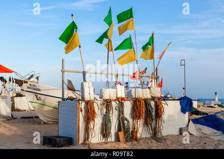 Angeln schwebt und Flaggen, die in der Abendsonne am Strand von Monte Gordo, Algarve, Portugal Stockfoto