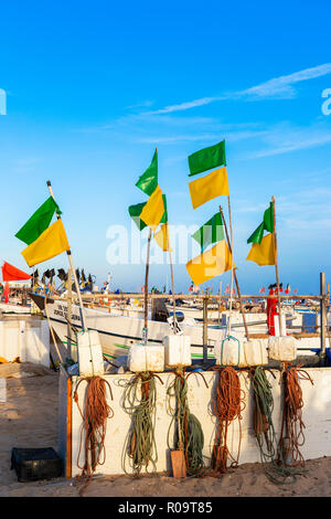 Angeln schwebt und Flaggen, die in der Abendsonne am Strand von Monte Gordo, Algarve, Portugal Stockfoto