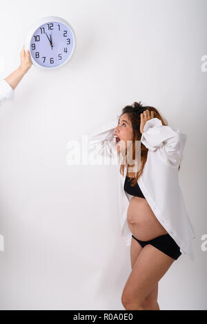 Portrait von schönen jungen schwangeren asiatische Frau suchen Clock Stockfoto