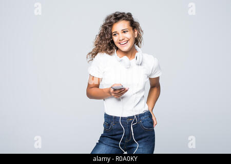 Latin Amerikanische Frau hören die Musik auf Handy über weiße Kopfhörer auf weißem Hintergrund Stockfoto