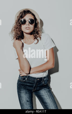 Portrait von curly Latin Frau legere Sommerkleidung in braunen Hut auf weißem Hintergrund. Stockfoto