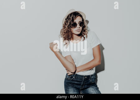 Portrait von curly Latin Frau legere Sommerkleidung in braunen Hut auf weißem Hintergrund. Stockfoto