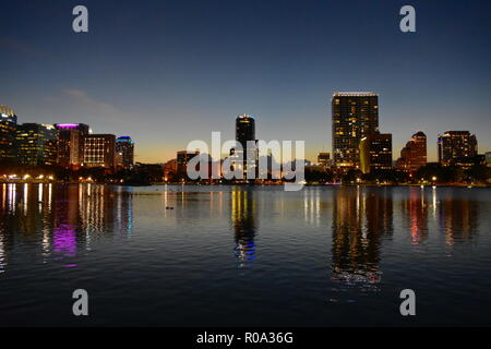 Orlando, Florida. Oktober 19, 2018 bunt beleuchteten Gebäuden im See mit Schwänen an Eola Lake Park in Orlando Downtown widerspiegelt. Stockfoto