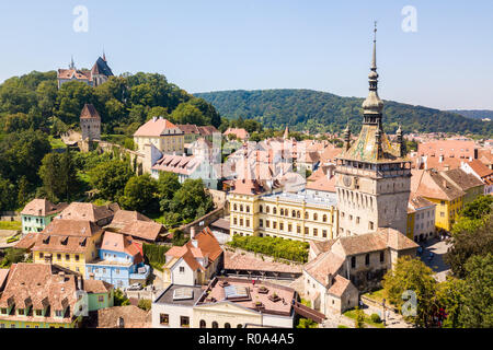 Grüne Hügel, Turmspitzen und roten Ziegeldächern, von Mauern umgebenen Altstadt von Sighisoara (Sighishoara), Mures, Siebenbürgen, Rumänien. Der Uhrturm von Sighișoara. Stockfoto