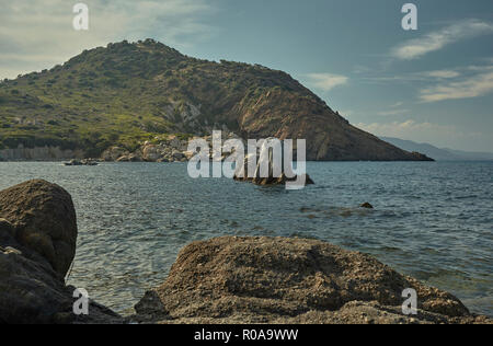 Wunderschöne felsige Küstenlandschaft mit Felsen, der vom Meer im Mittelmeer Strand der Cala sa Figu in Sardinien steigt. Stockfoto