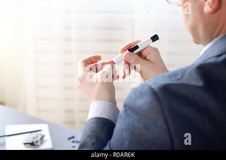 Mittleres Alter Mann Pierce seine Fingerspitze vor Blutprobe mit persönlichen glucometer. Für text Stockfoto