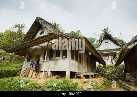 Traditionelle Holzhäuser mit dreieckigen Dach umgeben von grünen Wald in Kampung Naga Dorf, Tasikmalaya, West Java, Indonesien Stockfoto