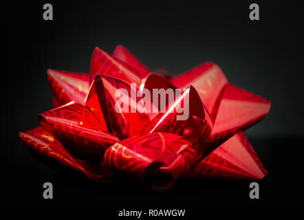 Ein (1) Weihnachten Satinschleife Ribbon - Satin Rot in der Farbe Schwarz Hintergrund. Zimmer für Kopieren. Stockfoto