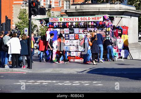 London, England, Vereinigtes Königreich. Touristen an und um ein Souvenir stand in der Nähe der Häuser des Parlaments an einem sonnigen Morgen in London. Stockfoto