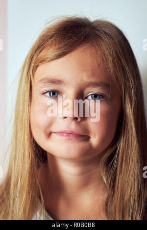 Portrait von entzückenden kleinen sechs oder sieben Jahre alten Mädchen fühlt sich unglücklich posiert an der Kamera schaut. Kopf schoss ganz schön frustriert, kleine Tochter Stockfoto