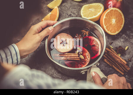 Die Glühwein und Zutaten im Topf auf rustikalen Hintergrund Stockfoto