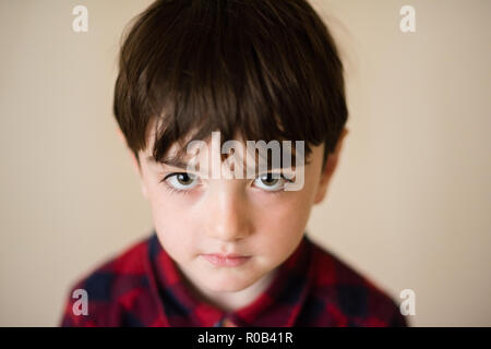 Portrait von kleinen einsam traurig nachdenklich kaukasischen Junge mit großen Augen in Plaid Shirt Stockfoto