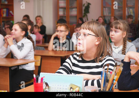 Schulmädchen mit Brille im Klassenzimmer Stockfoto