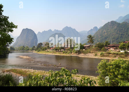 Einen malerischen Blick auf den Fluss Nam Song, Pha Tang Dorf und Kalkstein Berge in der Nähe von Vang Vieng, Vientiane, Laos, Provinz an einem sonnigen Tag. Stockfoto