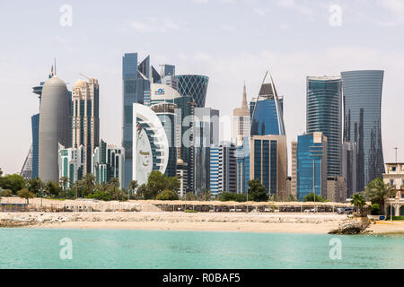 Die Skyline von Doha, Katar. Moderne reichen Nahen Osten Stadt der Wolkenkratzer, Aussicht bei gutem Wetter, Mittag, während der heiße, trockene Sommer, mit Blick auf den Strand. Stockfoto