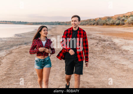 Oung Paar am Strand zusammen gehen Stockfoto