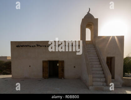 Abend Hintergrundbeleuchtung Silhouette einer alten Moschee am Sonnenuntergang, Barzan Wachtürme, gebaut mit Coral Rock und Kalkstein, alte arabische Moschee in der Nähe von Umm Stockfoto