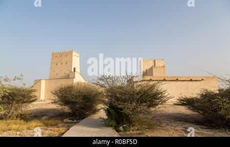 Zwei Barzan Wachtürme hinter Wüste Büsche, Umm Salal Mohammed Fort Türmen, alten arabischen Festung, in der Nähe der Stadt Doha, Katar. Stockfoto