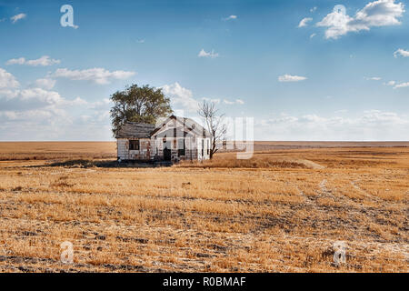 Ein verlassenes Haus steht ganz allein in der Mitte eines endlosen Weizenfeld im östlichen Washington. Stockfoto