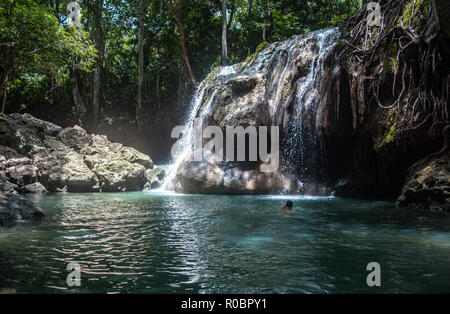 Touristische schwimmt in der Finca Paraíso, eine ungewöhnliche Wasserfall von heißen Quellen in einem eisigen türkis Süßwasser-Pool unten im Osten Guatemalas zugeführt Stockfoto