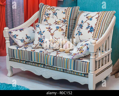 Dekorative Sofa mit weichen Kissen und ursprünglichen Farben im Innenraum Stockfoto