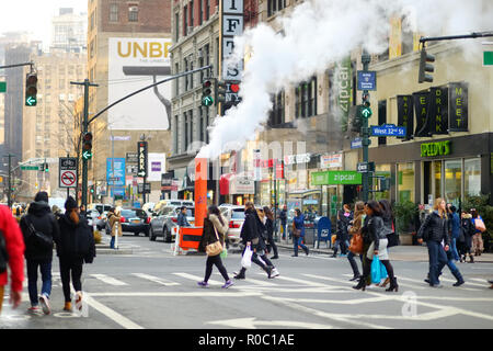 NEW YORK - 16. MÄRZ 2015: Menschen Überqueren einer Straße in der Innenstadt von Manhattan. Touristen und newyorkers zu Fuß über eine befahrene NYC Zebrastreifen. Stockfoto