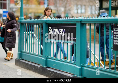 NEW YORK - 16. MÄRZ 2015: Menschen, die New Yorker U-Bahn. U-Bahn Zeichen auf grünem Stahl Zaun. Stockfoto