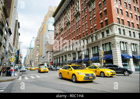 NEW YORK - 16. MÄRZ 2015: Gelbe Taxis und Menschen hetzen auf belebten Straßen von Downtown Manhattan. Taxis mit ihren unverwechselbaren gelben Farbe sind Stockfoto