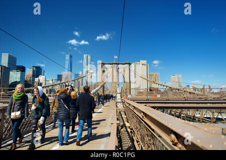 NEW YORK - 22. MÄRZ 2015: Menschen zu Fuß auf der Brooklyn Bridge. Touristen genießen Blick auf die Brooklyn Bridge und Manhattan Skyline im Hintergrund. Stockfoto