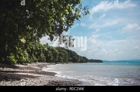 Dichten Wald gibt Weg für einen dunklen steinigen Strand am Kap von der Halbinsel Nicoya in Costa Rica, in der Nähe von Malpaís Stockfoto