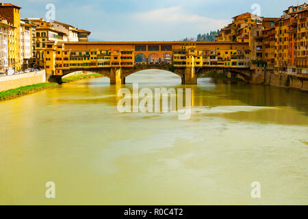 Vorderansicht in warmen Farben der mittelalterlichen Steinbrücke Ponte Vecchio über den Arno aus der Heiligen Dreifaltigkeit Brücke, Florenz, Toskana, Italien gesehen. Stockfoto