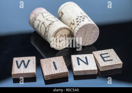 Zwei Korken neben ein paar Buchstaben aus Holz mit dem Wort Wein Stockfoto