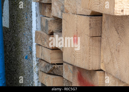 Kiefer holz Stapel von natürlichen groben Brettern auf der Baustelle. Industrieholz Baustoffe für Tischlerei, Gebäude in der Nähe. Stockfoto