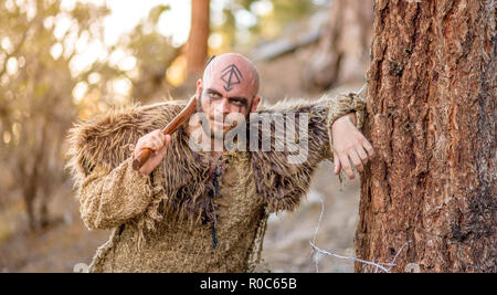 Ein männlicher Viking inspiriert Charakter in den Bergen. Modell das Tragen von echten Pelzen und Durchführung einer Ax Stockfoto