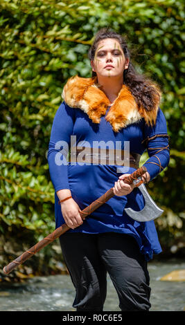 Eine weibliche Viking Charakter mit Fell und eine Axt am Fuße eines Berges. Fashion Editorial Einflüsse Stockfoto