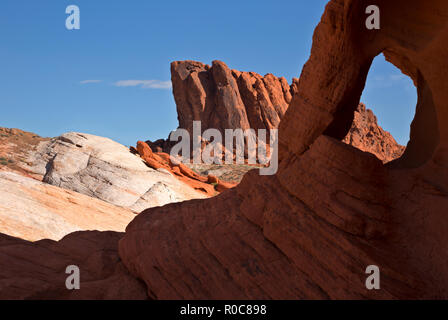 NV 00086-05 ... NEVADA - ein kleines Fenster durch Multi umgeben - farbige Schichten von Sandstein im Valley of Fire State Park gefunden. Stockfoto