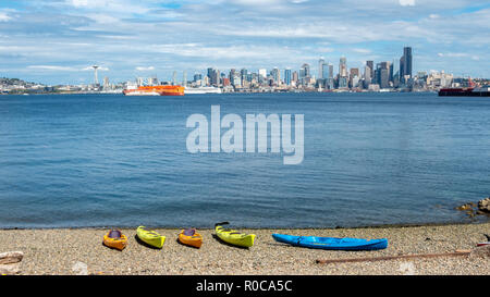 Mehrere Kajak auf Rock Beach mit Downtown Seattle Skyline im Hintergrund Stockfoto