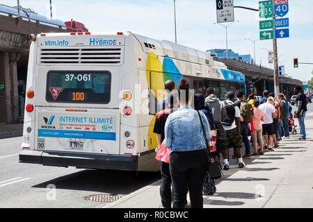 Menschen, die in der Warteschlange warten auf den öffentlichen Bus Station auf dem Bus in Montreal, Quebec, Kanada zu erhalten. Stockfoto