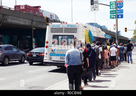 Menschen, die in der Warteschlange warten auf den öffentlichen Bus Station auf dem Bus in Montreal, Quebec, Kanada zu erhalten. Stockfoto