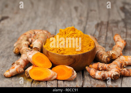 Kurkuma Pulver in hölzernen Schüsseln auf hölzernen Tisch Stockfoto